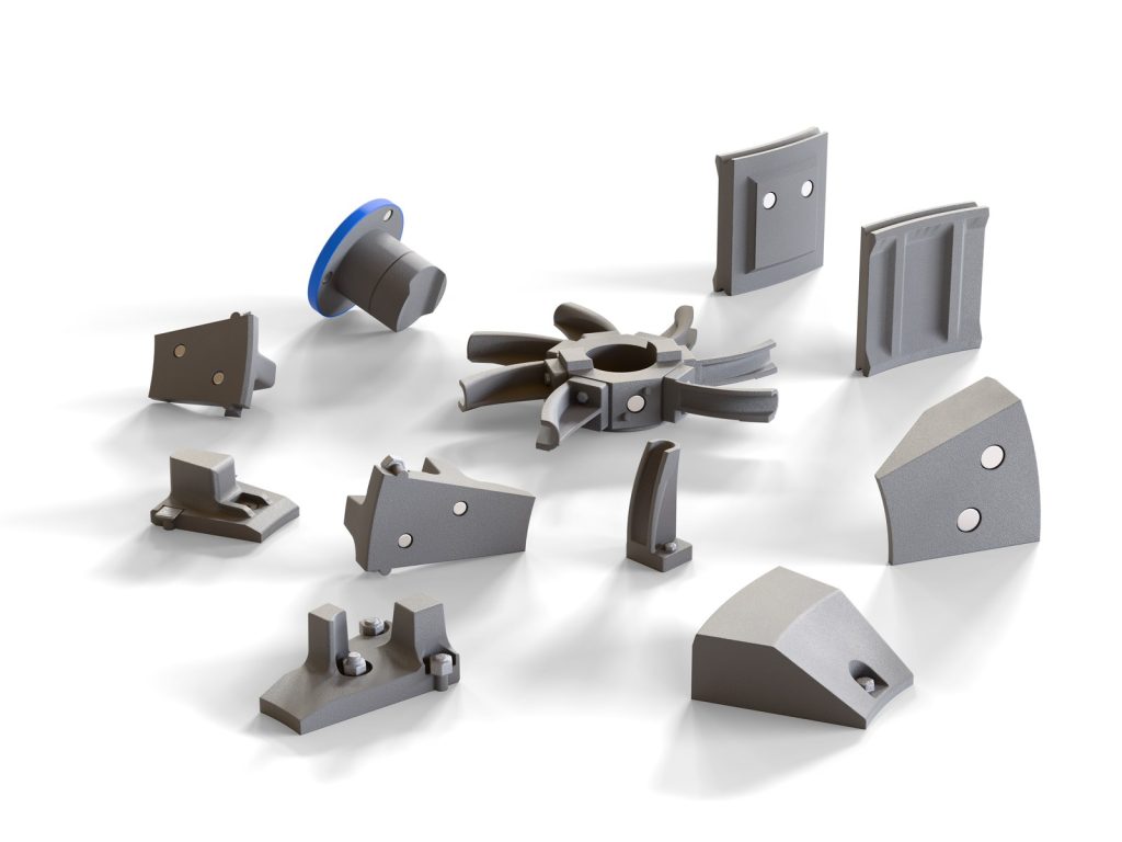 The model’s removable wear parts laid out on white: liner plates, rejector arms, rotor segments and the fan, with their magnets visible
